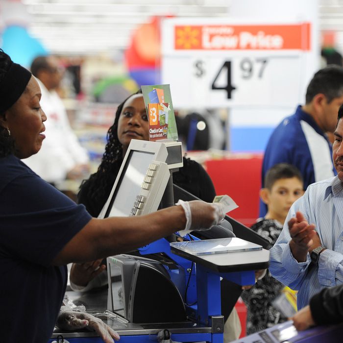 An employee rings up sales at a cash register at a Walmart in the Crenshaw district of Los Angeles on Black Friday, November 29, 2013. US stocks Friday moved higher in a holiday-shortened session following better eurozone economic data and positive early assessments of