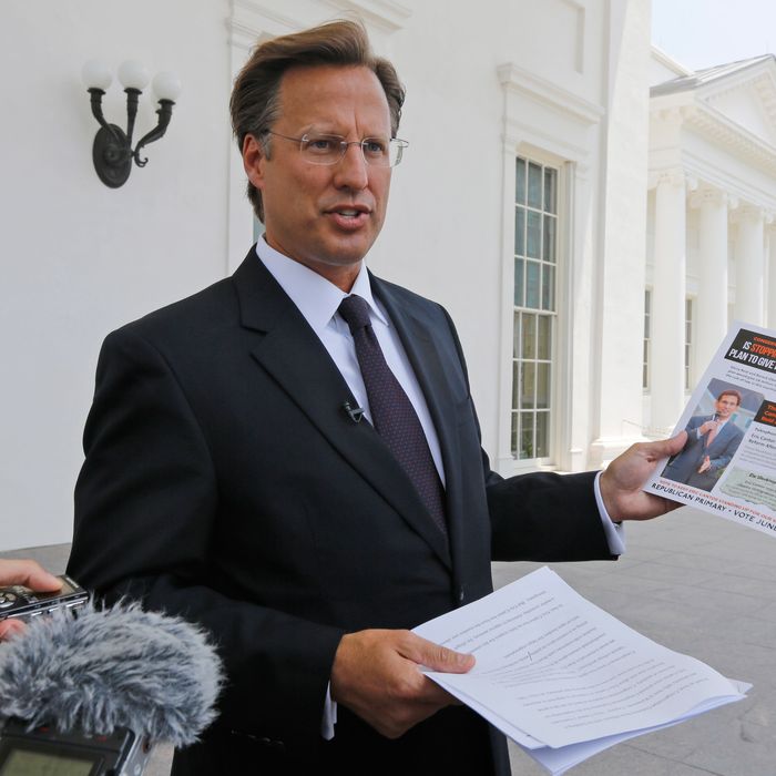 Seventh District US Congressional Republican candidate, David Brat displays an immigration mailer by Congressman Eric Cantor during a press conference at the Capitol in Richmond, Va., Wednesday, May 28, 2014. Brat challenged Congressman Eric Cantor's stand on immigration, claiming that Cantor backs amnesty. Cantor is getting pressured from both sides over immigration as his Republican primary election nears and the window for legislative action narrows. (AP Photo/Steve Helber)