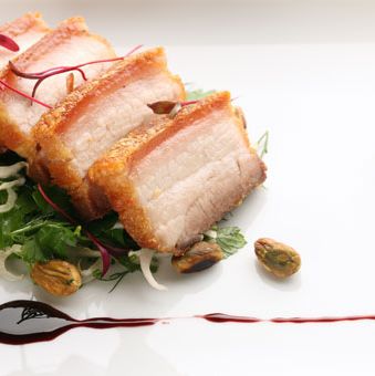 Braised Berkshire pork belly with pistachio nuts, aged port, and endive salad.