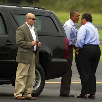 US President Barack Obama (C) speaks with New Jersey Governor Chris Christie (R) as he prepares to depart Paterson, New Jersey, September 4, 2011, after touring the devastation left by Hurricane Irene.
