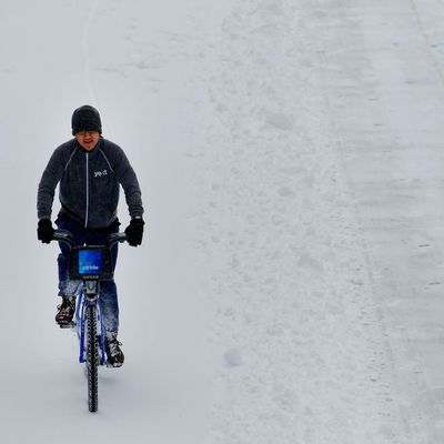 A bicyclist rides a Citi Bike through the snow in New York, U.S., on Friday, Jan. 3, 2014.