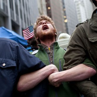 NEW YORK, NY - NOVEMBER 17: Protesters affiliated with the Occupy Wall Street movement lock arms at the intersection of Exchange Place and Beaver Street in the Financial District on November 17, 2011 in New York City. Protesters attempted to shut down the New York Stock Exchange today, blocking roads and tying up traffic in Lower Manhattan. (Photo by Andrew Burton/Getty Images)