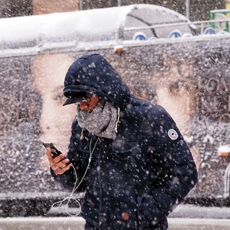 A man uses his smartphone as he crosses a street during a winter storm in New York on March 5, 2015. An airplane skidded of the runway Thursday at New York's La Guardia airport and hit a fence, officials said, as heavy snow fell in the city. Forecasters had warned of low visibility as a major storm hits the region. AFP PHOTO/JEWEL SAMAD (Photo credit should read JEWEL SAMAD/AFP/Getty Images)