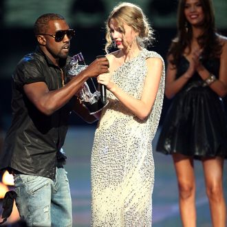 Kayne West (L)jumps onstage after Taylor Swift (C) won the 