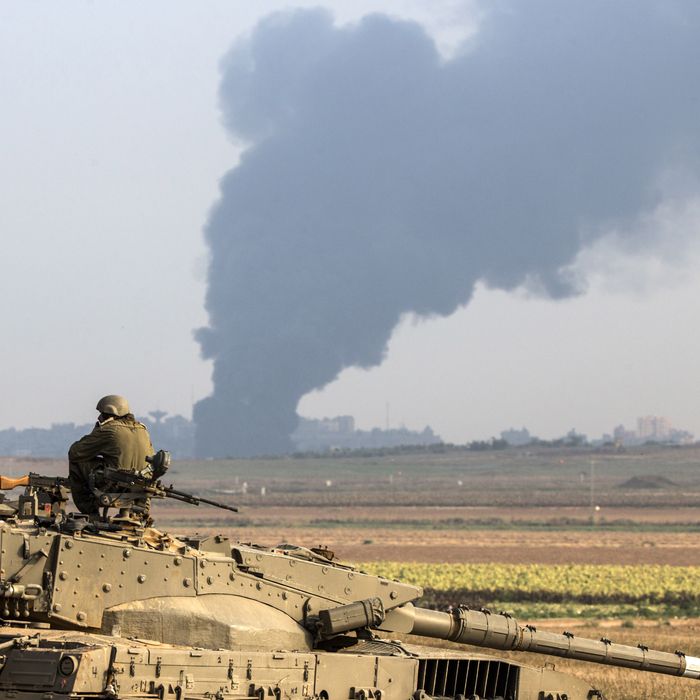 Israeli soldiers sitting on a tank hold their position on the Israeli side of the border with the Gaza Strip, on July 22 , 2014, as smoke billows from the coastal Palestinian enclave following an Israeli army ground operation to destroy tunnels reportedly used by Palestinian militants from the Gaza Strip to enter Israel. The UN chief and Washington's top diplomat are holding a flurry of meetings in Cairo to push for an end to two weeks of violence in Gaza that has killed sp far 585 Palestinians. AFP PHOTO / JACK GUEZ (Photo credit should read JACK GUEZ/AFP/Getty Images)