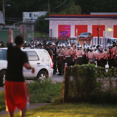 FERGUSON, MO - AUGUST 11: Police force protestors from the business district into nearby neighborhoods on August 11, 2014 in Ferguson, Missouri. Police responded with tear gas and rubber bullets as residents and their supporters protested the shooting by police of an unarmed black teenager named Michael Brown who was killed Saturday in this suburban St. Louis community. Yesterday 32 arrests were made after protests turned into rioting and looting in Ferguson. (Photo by Scott Olson/Getty Images)