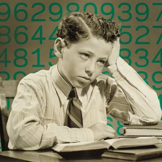 Boy (10-11) sitting at table over open book, head resting on hand, (B&W), close-up