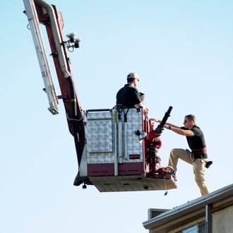 AURORA, CO - JULY 21: A law enforcement official climbs onto the roof of an adjacent building as they prepare to disarm the booby-trapped apartment of suspect James Holmes after he went on a shooting rampage at nearby Century 16 movie theatre during an early morning screening of the new Batman movie, 'The Dark Knight Rises' on July 21, 2012 in Aurora, outside of Denver, Colorado. According to reports, 12 people have been killed and over 59 injured. Police have the suspect, twenty-four year old James Holmes of North Aurora, in custody and are now dealing with various devices and trip wires in the apartment. (Photo by Chris Schneider/Getty Images)
AURORA, CO - JULY 21: Candles still burn at a makeshift memorial behind the Century 16 movie theater the day after a gunman killed 12 people and injured 59 during an early morning screening of 'The Dark Knight Rises' July 21, 2012 in Aurora, Colorado. Police in Aurora, a suburb of Denver, say they have a suspect James Holmes, 24, in custody. (Photo by Chip Somodevilla/Getty Images)