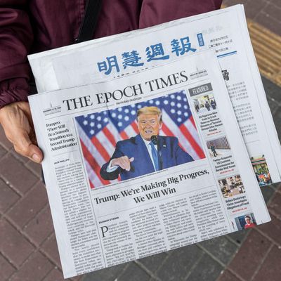 A woman distributes the multi-language newspapers The Epoch Times newspaper featuring on its front cover the former US President Donald J. Trump in Hong Kong.