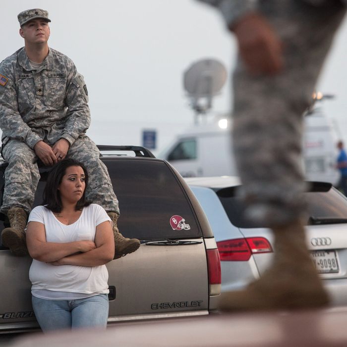 Lucy Hamlin and her husband, Spc. Timothy Hamlin, wait for permission to re-enter the Fort Hood military base, where they live, following a shooting on base on Wednesday, April 2, 2014, in Fort Hood, Texas. One person was killed and 14 injured in the shooting, and officials at the base said the shooter is believed to be dead. The details about the number of people hurt came from two U.S. officials who spoke on condition of anonymity because they were not authorized to discuss the information by name. (AP Photo/ Tamir Kalifa)