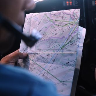 A pilot uses a map on board a Vietnamese Air Force Russian-made AN-27 aircraft during a search flight over Vietnam's southern sea aimed at finding the Malaysia Airlines' missing flight MH370 on March 14, 2014. The needle-in-a-haystack hunt for the missing Malaysian airliner spread to the vast Indian Ocean after the White House cited 