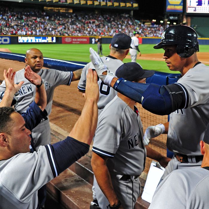 Alex Rodriguez #13 of the New York Yankees is congratulated by teammates after hitting an 8th inning grand slam against the Atlanta Braves at Turner Field on June 12, 2012 in Atlanta, Georgia.
