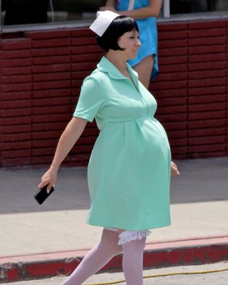 Joaquin Phoenix gets into character while carrying his boots and walking barefoot on the set of 'Inherent Vice' in Los Angeles. Maya Rudolph, who is expecting her fourth child with the film's director Paul Thomas Anderson, showed off a huge baby bump in green scrubs as she walked around set.