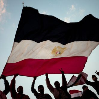 Anti-government demonstrators wave an Egyptian flag in Tahrir Square on February 11, 2011 in Cairo, Egypt. After 18 days of widespread protests, Egyptian President Hosni Mubarak, who has now left Cairo for his home in the Egyptian resort town of Sharm el-Sheik, announced that he would step down. 