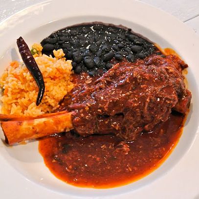 羊小腿用辣椒，华杰，和epazote炖，米饭和豆子