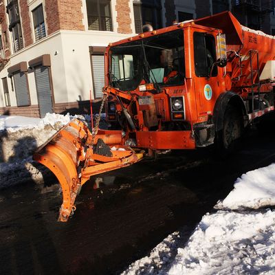 A plow clears the road of snow at the intersection of 126th Street and 5th Avenue on December 28, 2010 in New York City.