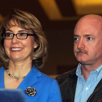 U.S. Rep. Gabrielle Giffords, left, and her husband Mark Kelly appear at a news conference following a tour of the New EastCoast Arms Collectors Associates arms fair in Saratoga Springs, N.Y. on Sunday, Oct. 13, 2013.