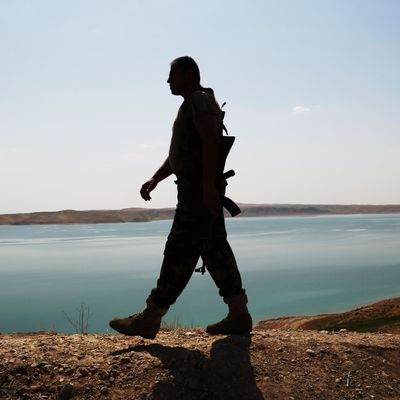 A Kurdish peshmerga fighter patrols near the Mosul Dam at the town of Chamibarakat outside Mosul, Iraq, Sunday, Aug. 17, 2014. 