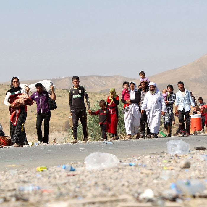 Displaced Iraqi families from the Yazidi community cross the Iraqi-Syrian border at the Fishkhabur crossing, in northern Iraq, on August 13, 2014. At least 20,000 civilians, most of whom are from the Yazidi community, who had been besieged by jihadists on a mountain in northern Iraq have safely escaped to Syria and been escorted by Kurdish forces back into Iraq, officials said. The breakthrough coincided with US air raids on Islamic State fighters in the Sinjar area of northwestern Iraq on August 9, and Kurdish forces from Iraq, Syria and Turkey working together to break the siege of Mount Sinjar and rescue the displaced AFP PHOTO/AHMAD AL-RUBAYE (Photo credit should read AHMAD AL-RUBAYE/AFP/Getty Images)
