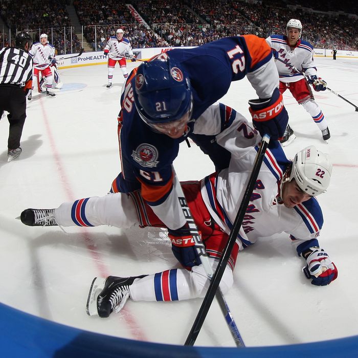 UNIONDALE, NY - OCTOBER 15: Kyle Okposo #21 of the New York Islanders hits Brian Boyle #22 of the New York Rangers at the Nassau Veterans Memorial Coliseum on October 15, 2011 in Uniondale, New York. (Photo by Bruce Bennett/Getty Images)