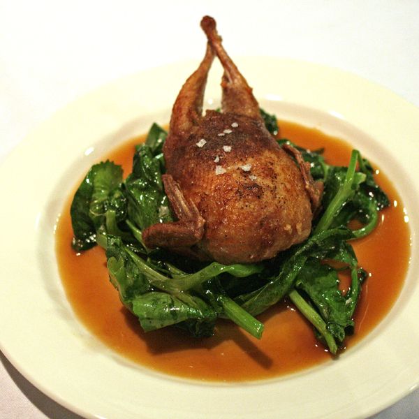 Masak's roasted quail stuffed with rice, chestnut, lotus seed, salted duck yolk, and kale.