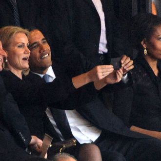  US President Barack Obama (R) and British Prime Minister David Cameron pose for a picture with Denmark's Prime Minister Helle Thorning Schmidt (C) next to US First Lady Michelle Obama (R) during the memorial service of South African former president Nelson Mandela at the FNB Stadium (Soccer City) in Johannesburg on December 10, 2013. Mandela, the revered icon of the anti-apartheid struggle in South Africa and one of the towering political figures of the 20th century, died in Johannesburg on December 5 at age 95. 