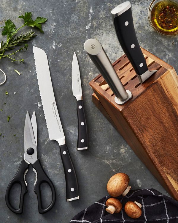 wooden knife set next to a cutting board with tomatoes, garlic, and peppers - strategist best kitchen knife sets