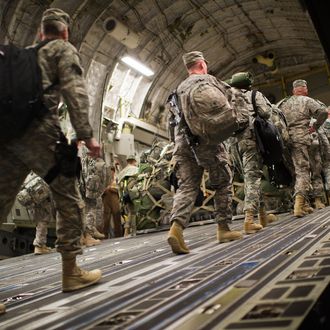 US soldiers board the last C17 aircraft carrying US troops out of Iraq at Camp Adder on the outskirts of the southern Iraqi city of Nasiriyah on December 17, 2011. From the tens of thousands killed and wounded to the hundreds of billions of dollars spent in eight years of conflict, the cost of the Iraq war is astronomic and still growing. AFP PHOTO/MARTIN BUREAU (Photo credit should read MARTIN BUREAU/AFP/Getty Images)