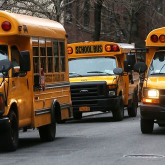 School buses idle in front of a school in Manhattan's East Village on January 15, 2013 in New York City. Drivers of the city's school buses are set to go on strike tomorrow after negotiations with Mayor Michael Bloomberg failed to reach an agreement; over 150,000 children will need to find an alternate method of transportation to school.