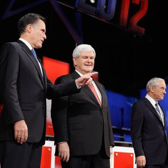 TAMPA, FL - JANUARY 23: Republican presidential candidates, former Massachusetts Gov. Mitt Romney and former Speaker of the House Newt Gingrich (R-GA) interact while U.S. Rep. Ron Paul (R-TX) looks on prior to the NBC News, National Journal, Tampa Bay Times debate held at the University of South Florida on January 23, 2012 in Tampa, Florida. The debate is the first of two before the Florida primaries on January 31st. (Photo by Chip Somodevilla/Getty Images)