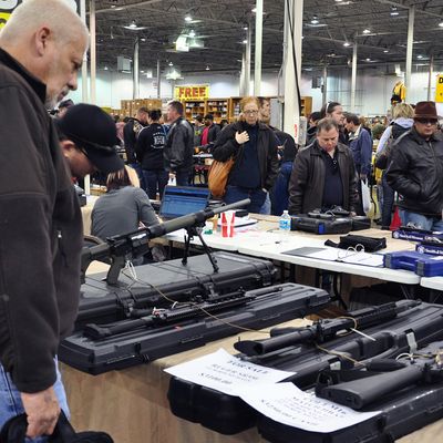 Gun show goers look at various assault-style weapons December 30, 2012 at the Nation's Gun Show in Chantilly, Virginia. Since the Connecticut school shootings, gun sales, particularly assault-style weapons have gone up sharply.