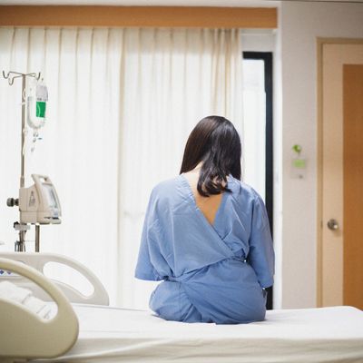 Worried patient women sitting up in the hospital bed with sadness emotion