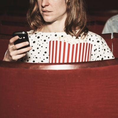 Man and woman using their phones in theater