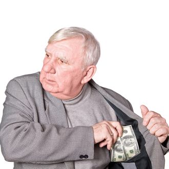 Elderly man puts money in an internal pocket of a jacket. It is isolated on a white background