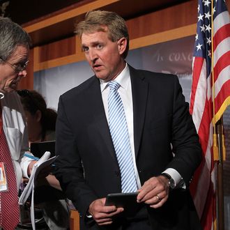 U.S. Sen. Jeff Flake (R-AZ) (R) talks to a reporter at the end of a news conference March 6, 2013 on Capitol Hill in Washington, DC. The senators held a news conference on legislation to prevent gun violence. 