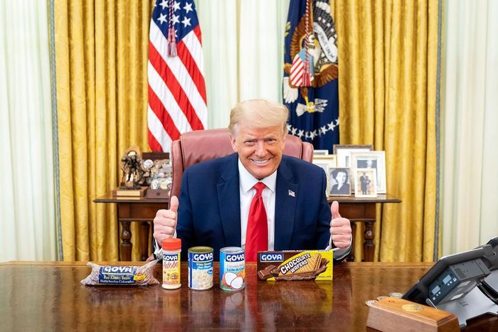 President Donald Trump poses with cans and bags of GOYA beans in the Oval Office.