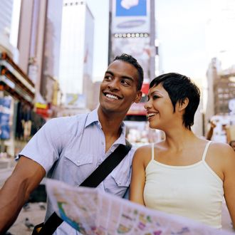 USA, New York, New York City, young couple holding map in Times Square