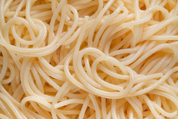 Spaghetti or pasta on a ceramic plate, isolated on a white background or table. The concept of Vegetarian and Vegan Food. Food background. Copy of the text space.