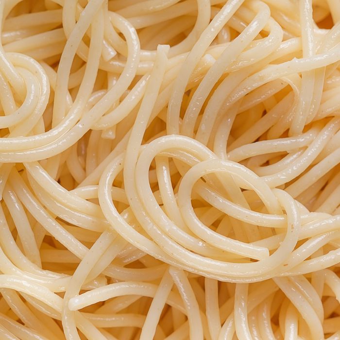 Spaghetti or pasta on a ceramic plate, isolated on a white background or table. The concept of Vegetarian and Vegan Food. Food background. Copy of the text space.