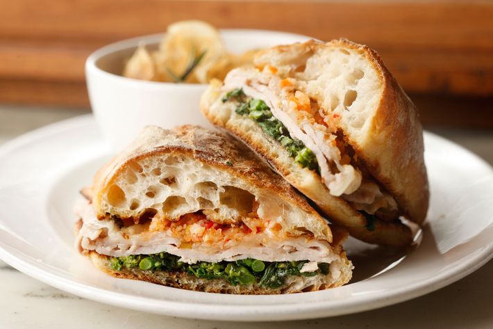 Roast-pork sandwich with broccoli rabe, giardiniera, provolone, and chips.