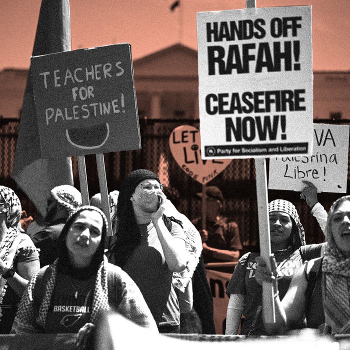 A group of protesters stands in front of the White House, many of them wearing keffiyehs. They hold signs reading 