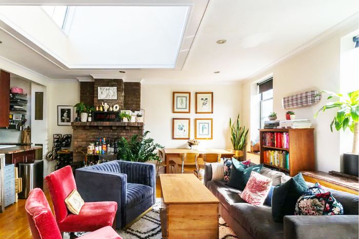 Living room with a brick fireplace and huge skylight.