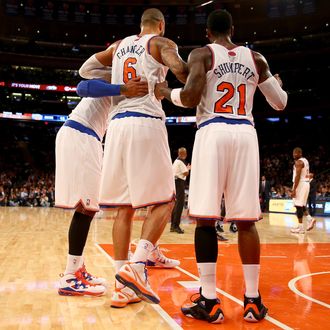 Tyson Chandler #6 of the New York Knicks is helped off the court by teamamtes Iman Shumpert #21 and Carmelo Anthony #7 in the first quarter against the Charlotte Bobcats at Madison Square Garden on November 5, 2013 in New York City.