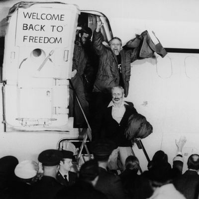 January 1981: United States hostages departing an airplane on their return from Iran after being held for 444 days. One of the hostages is waving his fists in the air, and a sign on the plane door says, 'Welcome Back to Freedom'. 